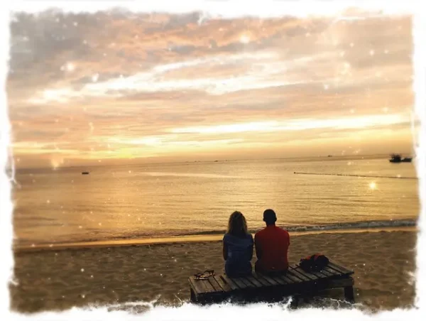 couple facing ocean at dusk, Thailand