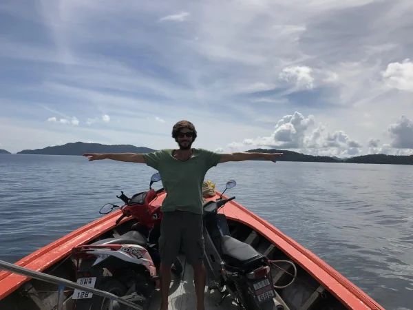 ВК в Таиланде с раскрытыми руками и байком на лодке